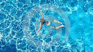 Active girl in swimming pool aerial drone view from above, young woman swims in blue water, tropical vacation