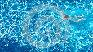 Active girl in swimming pool aerial drone view from above, young woman swims in blue water, tropical vacation