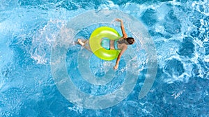 Active girl in swimming pool aerial drone view from above, young woman swims in blue water, tropical vacation