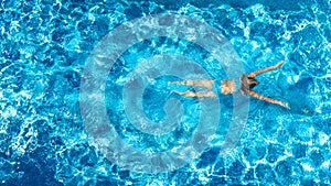 Active girl in swimming pool aerial drone view from above, young woman swims in blue water, tropical vacation, holiday on resort