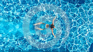 Active girl in swimming pool aerial drone view from above, young woman swims in blue water, tropical vacation, holiday on resort