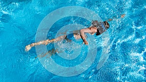 Active girl in swimming pool aerial drone view from above, young woman swims in blue water, tropical vacation, holiday on resort