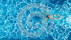 Active girl in swimming pool aerial drone view from above, young woman swims in blue water, tropical vacation, holiday on resort