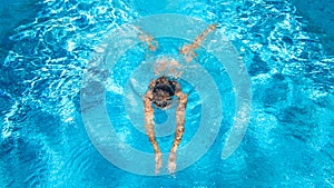 Active girl in swimming pool aerial drone view from above, young woman swims in blue water, tropical vacation, holiday on resort