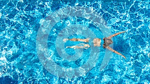 Active girl in swimming pool aerial drone view from above, young woman swims in blue water, tropical vacation