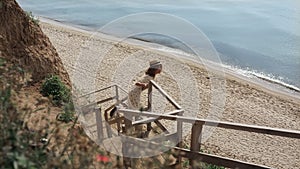 Active girl watching seascape standing beach ladder. Woman running to ocean.