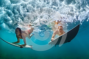 Active girls in bikini in dive action on surf board