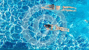 Active girls in swimming pool water aerial drone view from above, children swim, kids have fun on tropical family vacation