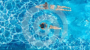 Active girls in swimming pool water aerial drone view from above, children swim, kids have fun on tropical family vacation