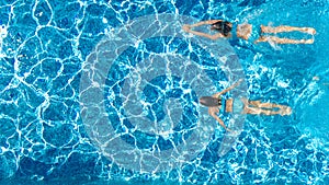 Active girls in swimming pool water aerial drone view from above, children swim, kids have fun on tropical family vacation