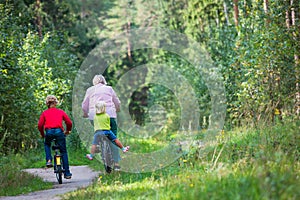 Active grandmother with kids riding bikes in nature