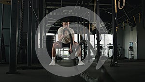 Active guy physical strength endurance exercise challenge powerful strong man squat pose training battle ropes at cardio
