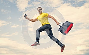 Active guy running with sporty bag midair sky background, sport