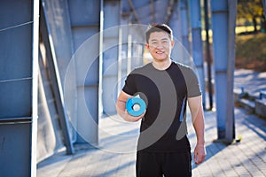 Active handsome male yogi walks in a stadium strolling before or after a workout. Young happy asian athletic man athlete