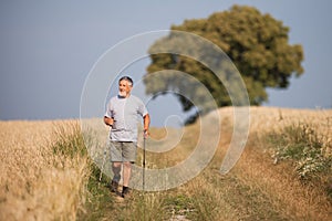 Active handsome senior man nordic walking outdoors
