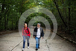 Active handsome senior walking with his daughter