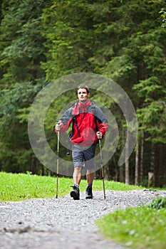 Active handsome young man nordic walking