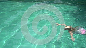 Active happy child in outdoor pool. Child girl six years old in a swimming pool outdoors