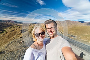 Active happy couple taking selfie on travel in high Atlas mountains, Ouarzazate, Morocco.