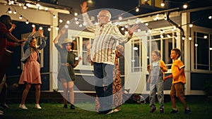 Active and Healthy Senior Man Dancing Together with Family and Friends at an Evening Garden Party