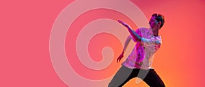 Active hip-hop dancer training isolated over over gradient multicolored background in neon light.