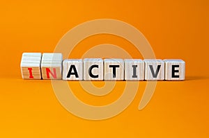 Active or inactive symbol. Turned wooden cubes and changed the concept word Inactive to Active. Beautiful orange table orange