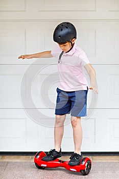 Active kid boy on hover board. Child driving modern balance hoverboard. Excercise and sports for children, outdoor