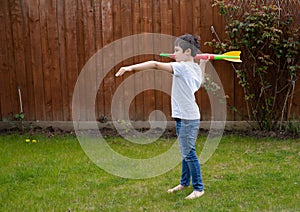 Active kid preparing to throwing a Javelin, Healhty Child practicing athletics throw Javelin. Young boy playing in the back garden