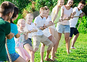 Active kids with parents playing tug of war