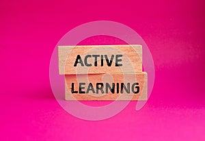 Active learning words written on wooden blocks with pink background