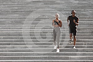 Active Lifestyle. Black Jogger Couple Running Down On Urban Stairs, Training Outdoors