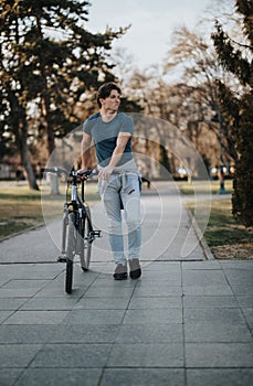 Active lifestyle concept with a man and his bicycle in a park setting