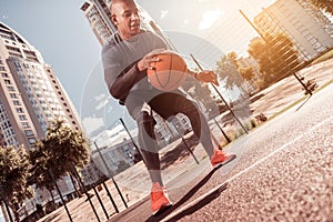 Nice active young man playing basketball game photo