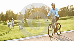 Active lifestyle. Young athletic man in sportswear and protective helmet riding mountain bike in park during sunset