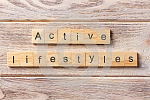 Active lifestyles word written on wood block. Active lifestyles text on table, concept