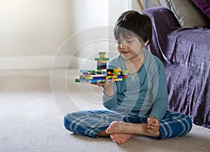 Active little boy playing with construction plastic toy blocks, Kid playing colorful toys in playroom at home, Toddler development