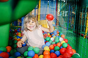 Active little girl playing in indoor playground. Happy joyful preschool child climbing, running, jumping and having fun