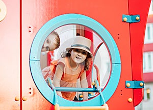 Active little girl and teen boy children on playground kindergarten yard having fun. Summer children activity. Happy