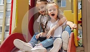 active little girls on playground. playing child on slide