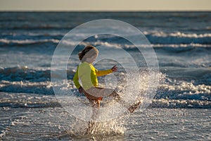 Active little kid running along sea beach during leisure sport activity. Sporty kid running in nature. Child run at