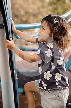 Active little toddler girl on the playground in summer time, childhood memories and active kids concept