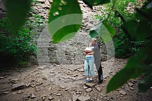 Active loving senior couple walking in beautiful summer forest