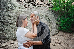 Active loving senior couple walking in beautiful summer forest