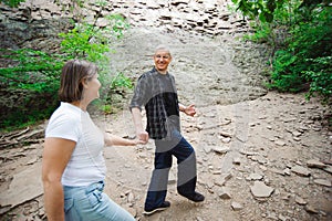 Active loving senior couple walking in beautiful summer forest - active retirement concept