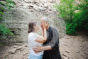 Active loving senior couple walking in beautiful summer forest