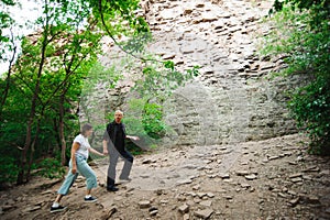 Active loving senior couple walking in beautiful summer forest - active retirement concept.