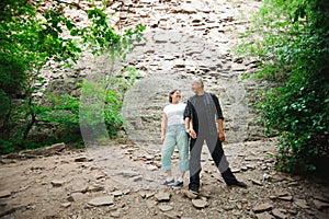 Active loving senior couple walking in beautiful summer forest - active retirement concept.