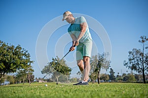 active male golf player on professional course with green grass, golfing