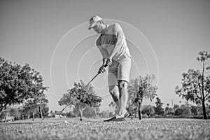 active male golf player on professional course with green grass, golfing