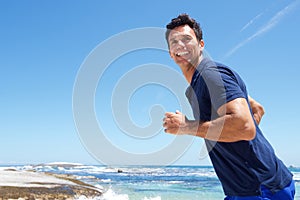 Active man casually running at the beach